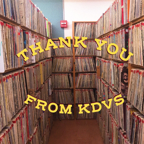 A photo of the interior of a radio station, showing a narrow hallway filled with shelves of records. Text over the photo reads Thank you from KDVS.