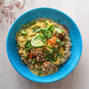 A photo of a bowl of thai curry over rice.
